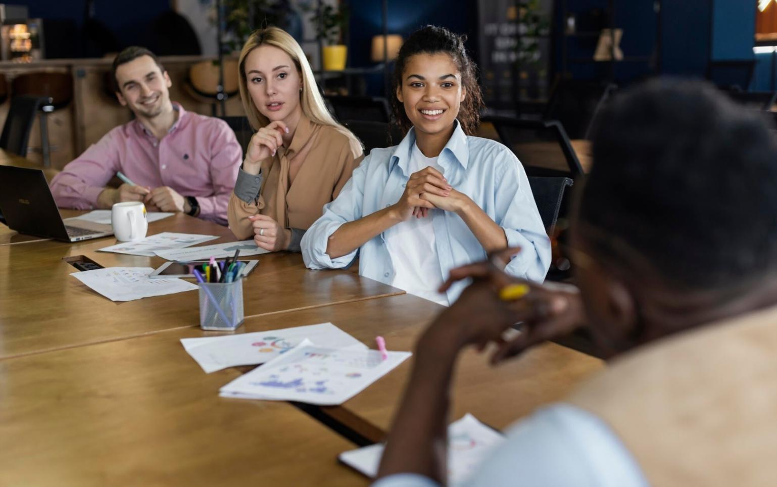 Seseorang menganalisis dokumen finansial dengan laptop dan kalkulator